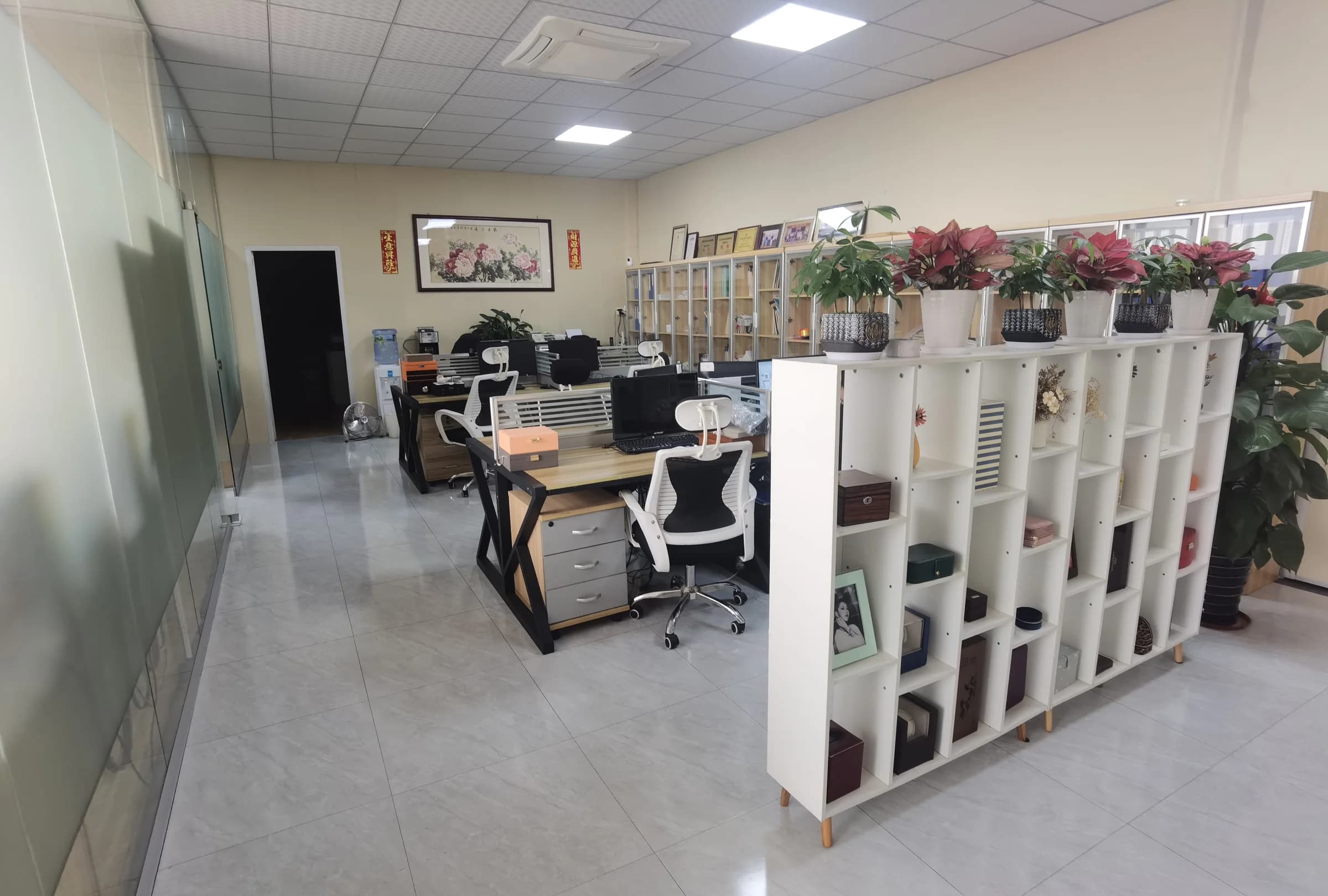Office desks beside shelves holding jewelry box samples