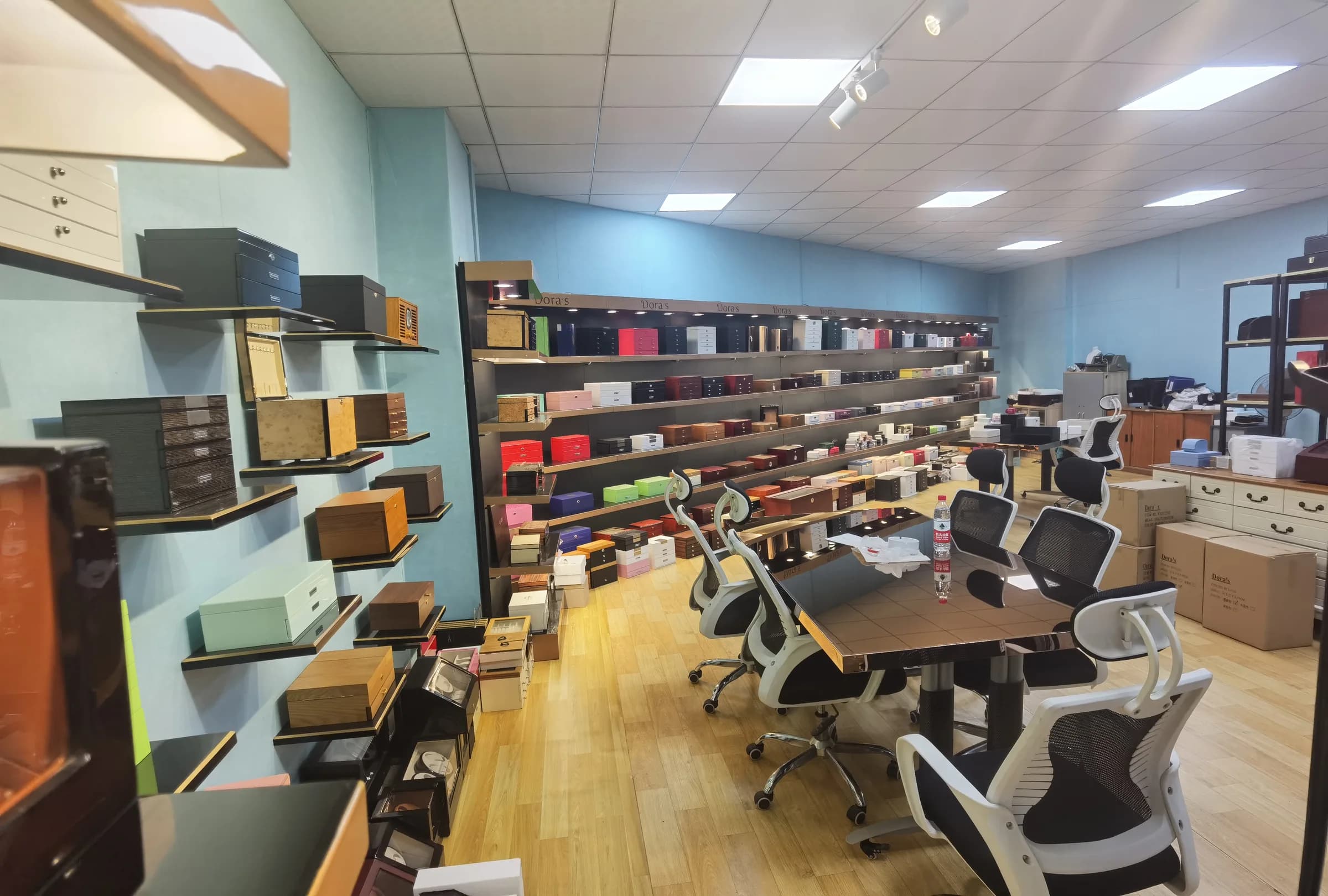 Sample display room with jewelry boxes on shelves and a meeting table