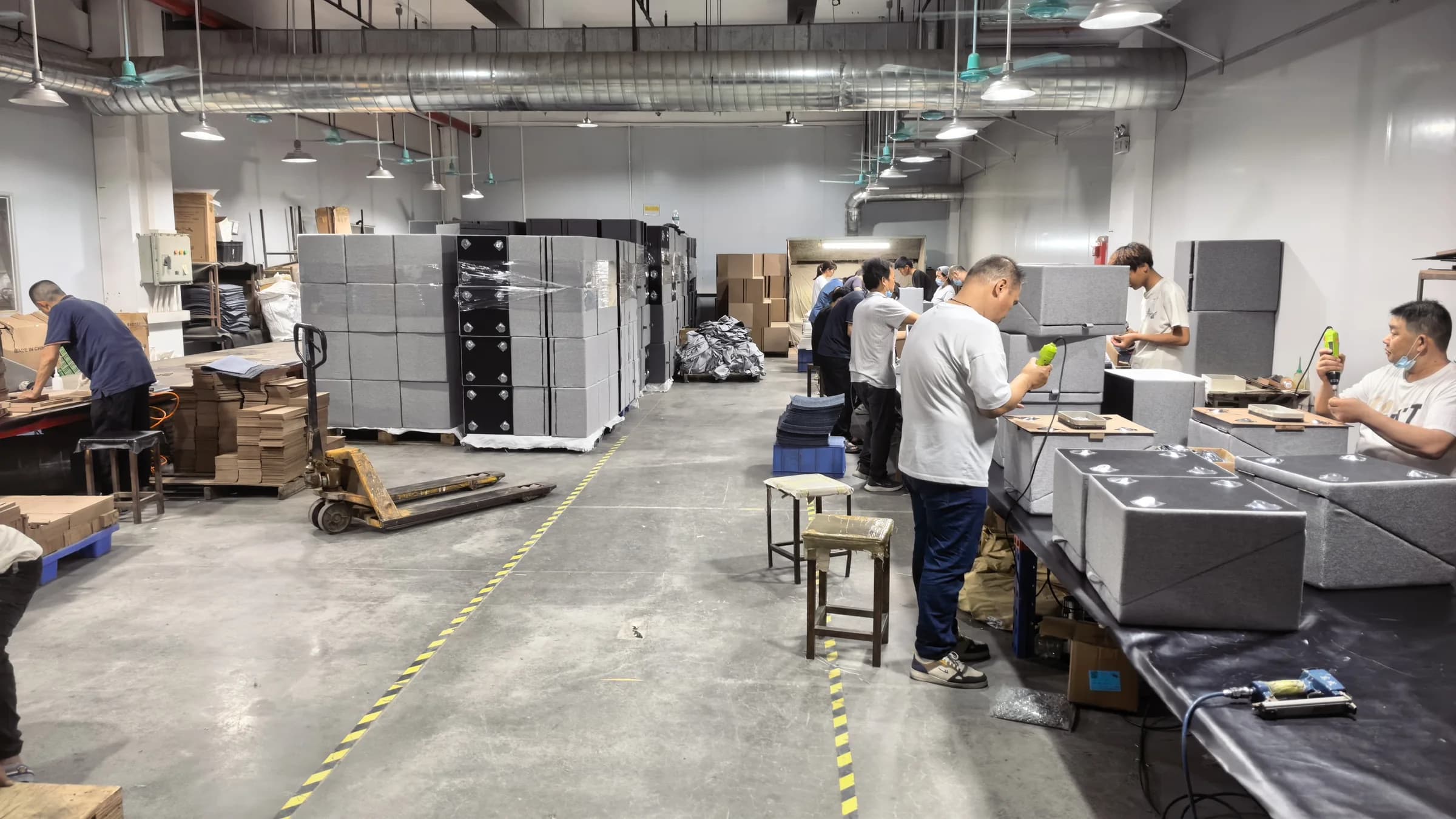Wide view of the workshop with assembly stations, employees and stacked components