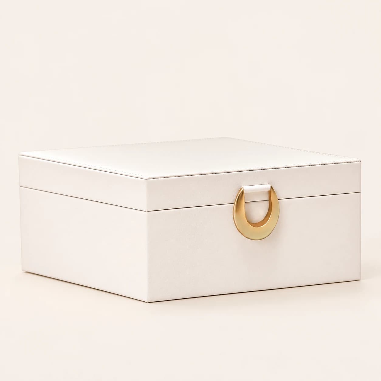 White solid-lid jewelry box with a ring-shaped front clasp and no drawers